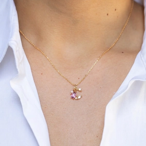 Elegant 18K gold star and moon necklace with pink teardrop stone and pearl on model