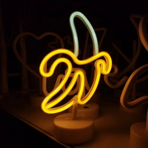 Neon banana LED table lamp with white base for festive bedroom decoration