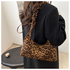 Détail du sac léopard avec bandoulière plissée et finitions délicates en ruban noué