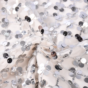 Détail macro de paillettes argentées sur mesh pour robes à paillettes sexy