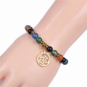 Dettaglio del bracciale con perline multicolore e ciondolo Om dorato in stile yoga
