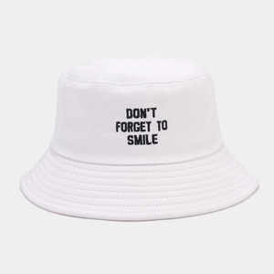 Detailed view of the 'DON'T FORGET TO SMILE' black embroidery on a white cotton bucket hat