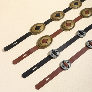 Detail of vintage PU leather belts with decorative etched metal buckles and inlaid stones