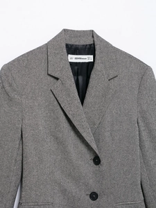 Macro detail of a grey textured blazer showing notch lapels and brand size label