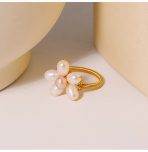 Detail of hand-woven flower ring with pink and white freshwater pearls on gold wire