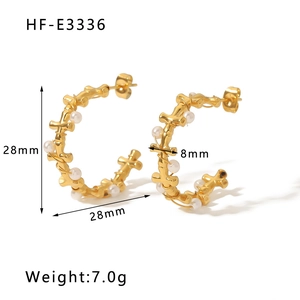 Detail view of gold C-shaped earrings with white pearl wrap including 28mm size markings