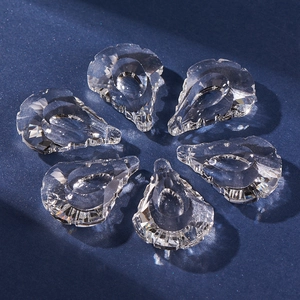 Macro view of six multifaceted waterdrop crystal pendants on a dark blue background