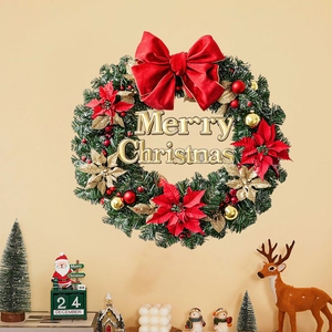 Christmas wreath with red velvet bow and golden Merry Christmas sign on beige wall