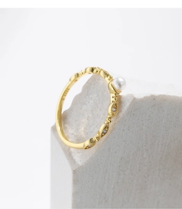 Macro shot of S925 sterling silver gold plated ring with crystal pearl on white stone