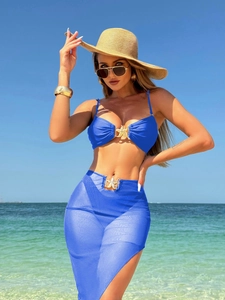 Dettaglio del top bikini blu e gonna in rete con fibbia dorata a forma di stella
