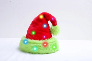 Detail of red Christmas hat with green faux fur trim and glowing LED lights on white background