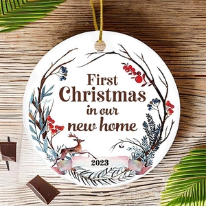 Ceramic First Christmas In Our New Home ornament with wreath and reindeer on wood