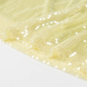 Gros plan d'un tissu de mini-jupe à paillettes jaune clair avec reflets scintillants