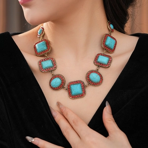 Modell trägt Vintage-Halskette mit türkisfarbenen Steinen und kleinen roten Diamanten