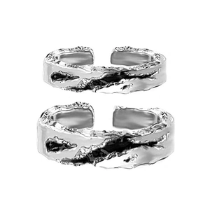 Detailed view of silver liquid metal style open rings for couples on white background