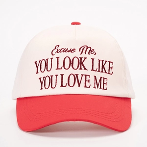 Red and white baseball cap with embroidered 'YOU LOOK LIKE YOU LOVE ME' slogan