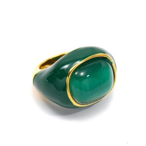 Detailed macro view of an vintage green oval gemstone set in a thick 18k gold plated band