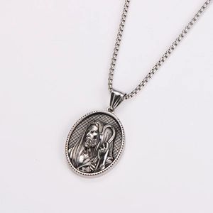 Macro view of silver oval Jesus relief pendant with detailed box chain necklace