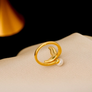 Golden mermaid tail ring with natural freshwater pearl on beige silk fabric background