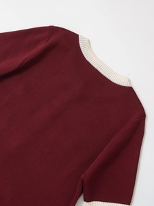 Detailed close-up of burgundy knit sweater collar with beige ribbed stitching texture