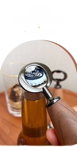 Detail of ergonomic wooden and zinc alloy bottle opener lifting a soda bottle cap
