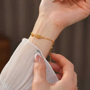 Détail du bracelet rose plaqué or 18 carats avec zircons et breloques de fleurs