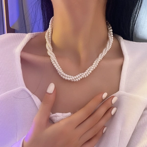Dettaglio dell'elegante collana di perle bianche a doppio strato indossata con stile chic