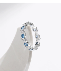Macro view of sterling silver eternity ring with blue aquamarine and clear crystals