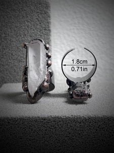 Detail view of vintage bronze adjustable ring with raw white crystal point and size markers