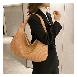 French woven khaki shoulder bag in PU leather shown on a model with black blazer