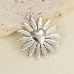 Macro shot of silver daisy pendant with heart-shaped center and metal texture