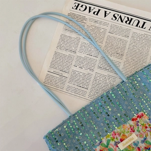 Detail of light blue sequined denim tote bag with floral patchwork and thin shoulder straps