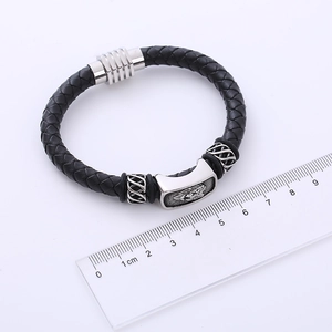 Dettaglio del bracciale in pelle intrecciata da 8-9cm con charm a testa di leone