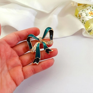 Vintage court style emerald enamel bow brooch with sparkling crystals in gold setting