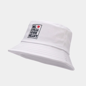 Détail d'un chapeau bob blanc en toile avec imprimé Mr. Steal Your Heart et cœur rouge