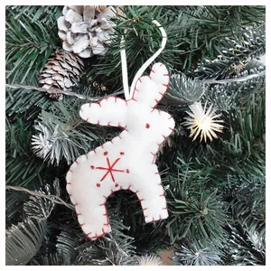 White felt reindeer ornament with red stitching and snowflake detail on a Christmas tree