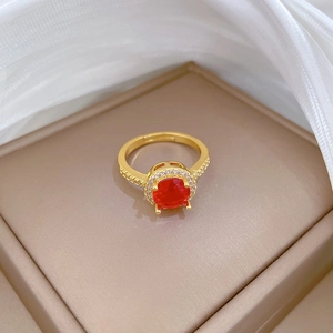 Detail showing an adjustable gold ring with a vibrant red ruby-style center stone in a gift box