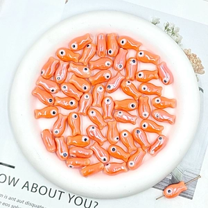 Macro shot of orange ceramic fish beads for handmade DIY bracelets and crafts