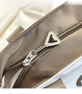 Detail eines hochwertigen Dreieck-Metall-Reißverschlusses an einer braunen Nylontasche