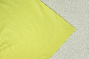 Detailed close-up of lime green high-density knitted fabric showing fine ribbed texture