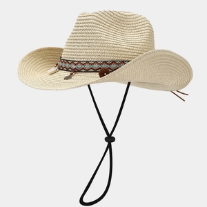 Dettaglio di cappello cowboy in paglia boho con decorazioni di conchiglie e fascia