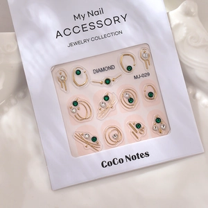 Detail of 3D nail art stickers MJ-029 with gold lines and green rhinestones in luxury tray