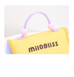 Detail of miloBliss logo on yellow canvas toiletry bag with purple handles and pink beads