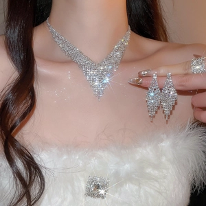 Close-up of sparkling V-shaped tassel jewelry set with crystals on elegant model