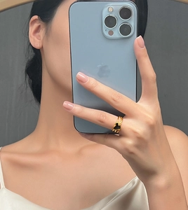 Détail d'une bague multicouche torsadée plaquée or avec un design de cœur en émail noir