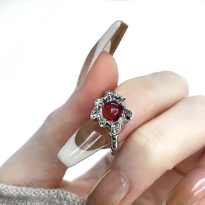 Irregular silver molten ring with a round red gemstone on a model's hand