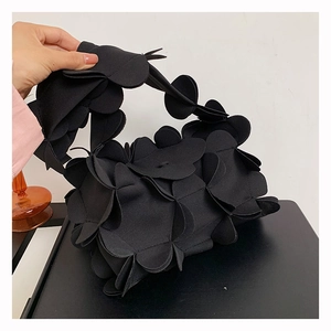 Close-up of a stylish black 3D petal handbag with matte texture and unique floral design