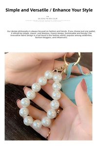 Detail of white pearl keychain featuring a sky blue crocodile pattern mini leather bag