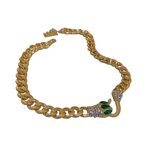Übertriebene goldene Schlangenkette mit funkelnden Strasssteinen und grünen Steinen