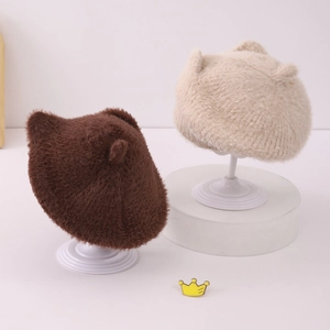 Détail des bérets en peluche marron et beige montrant la texture douce des oreilles